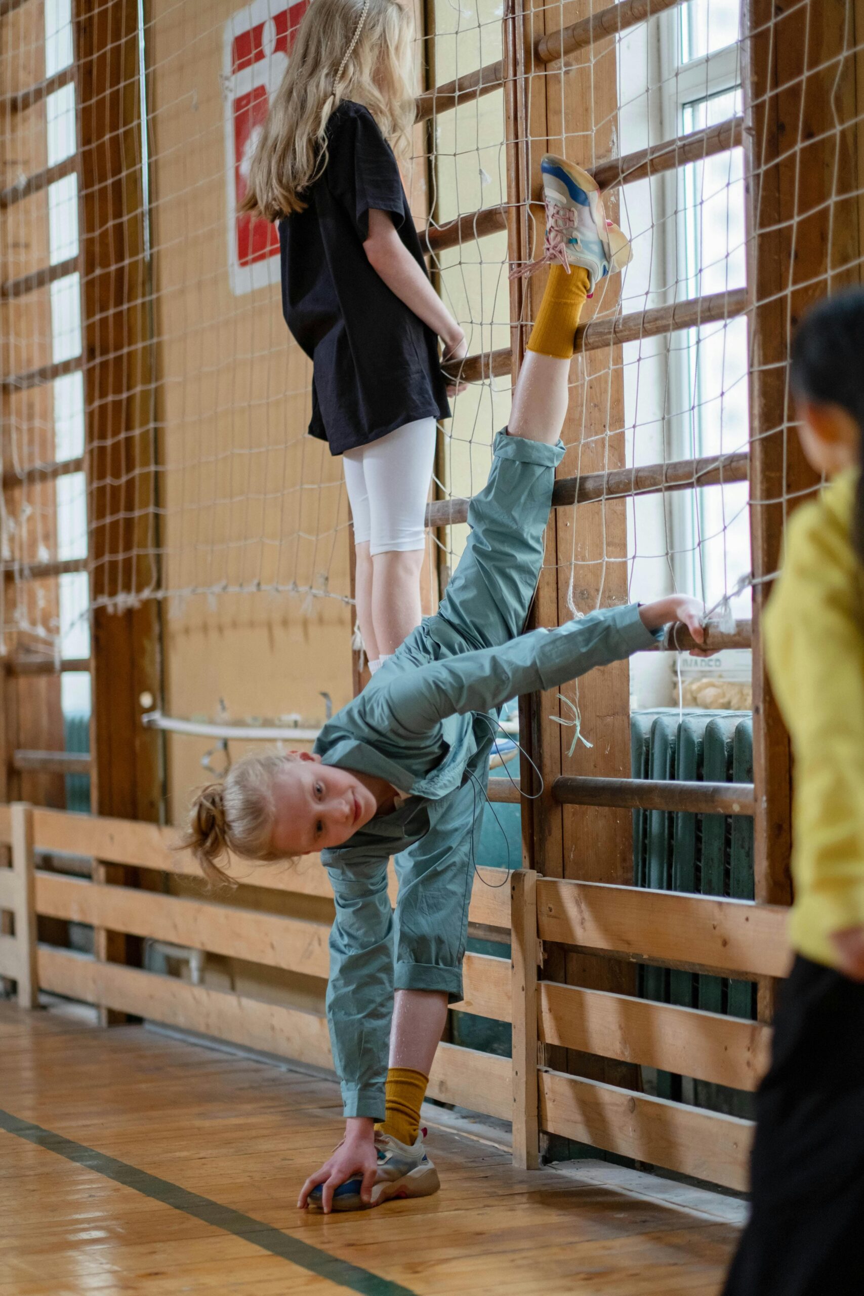 A Girl Stretching on a Net in the Gym