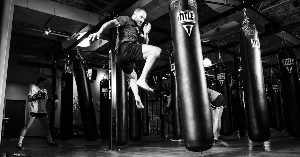 Action-packed scene of a man training in a gym with punching bags.