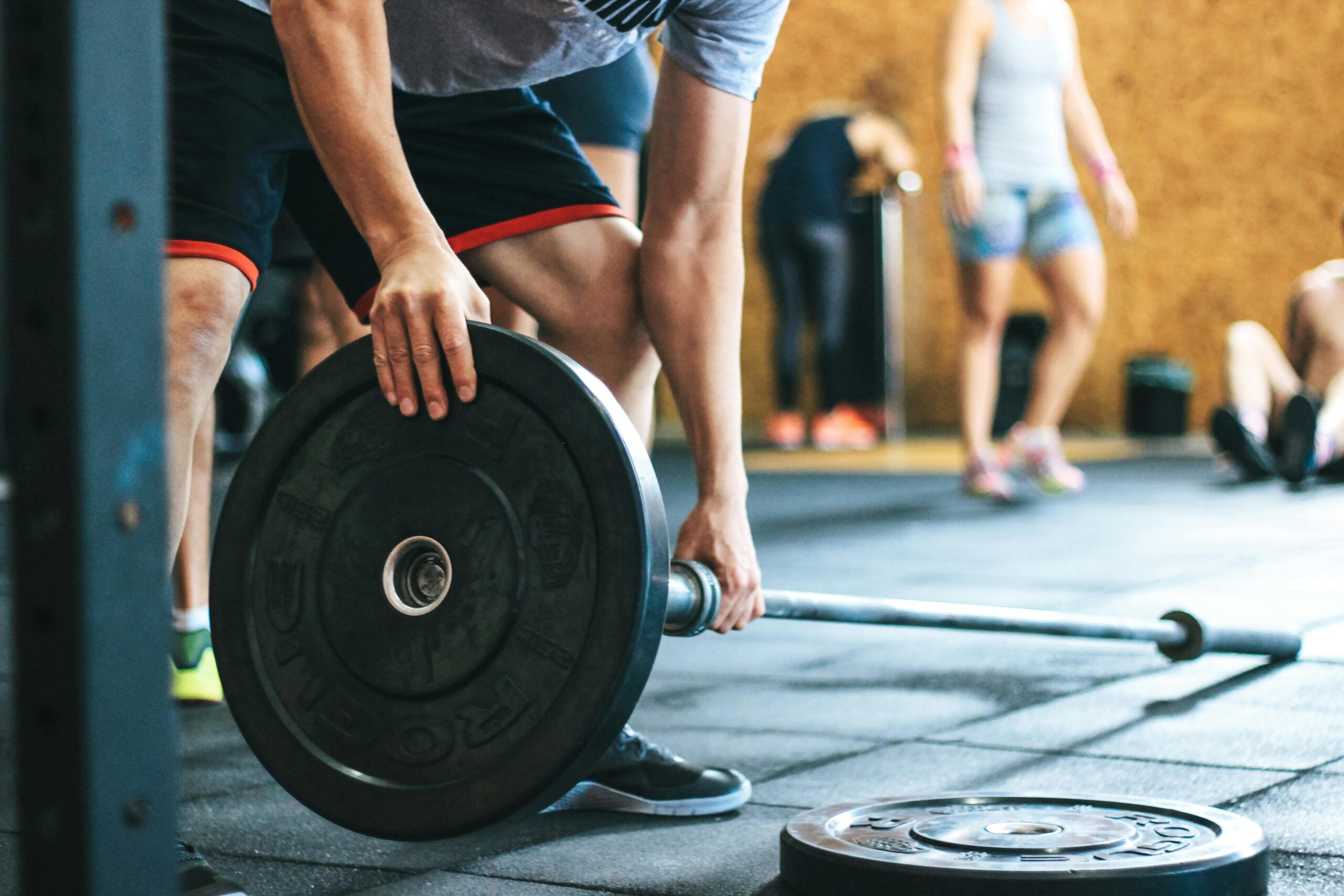 Man Holding Black Barbell in a usa gym