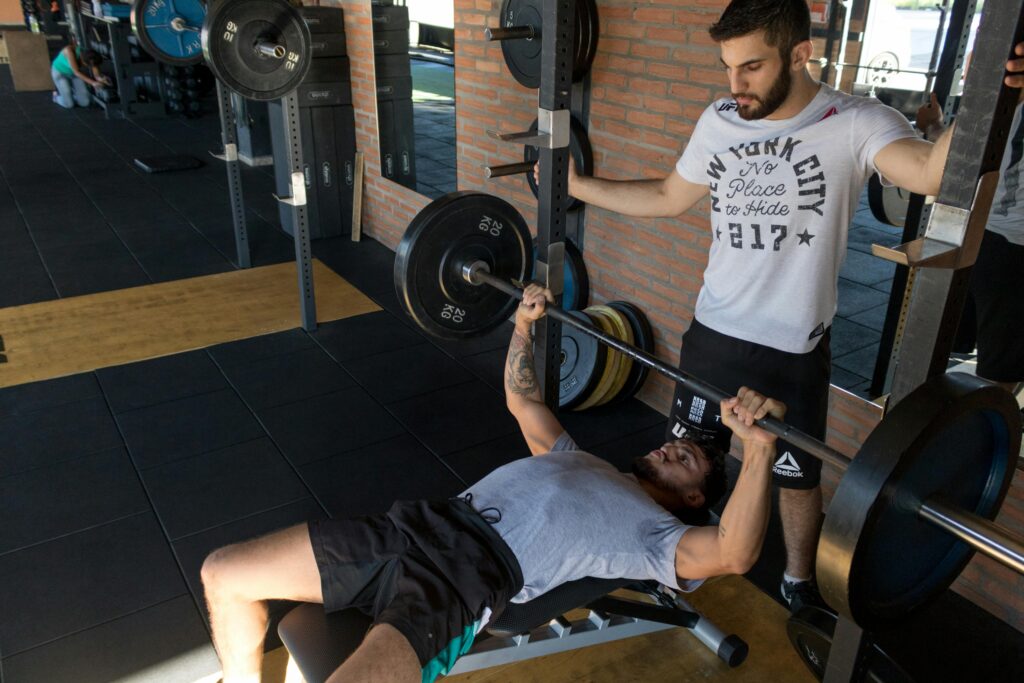Personal trainer guiding client through a strength training session in a private gym