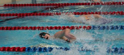 Swimmers in action during a competitive indoor swimming race in Montreal, Canada.